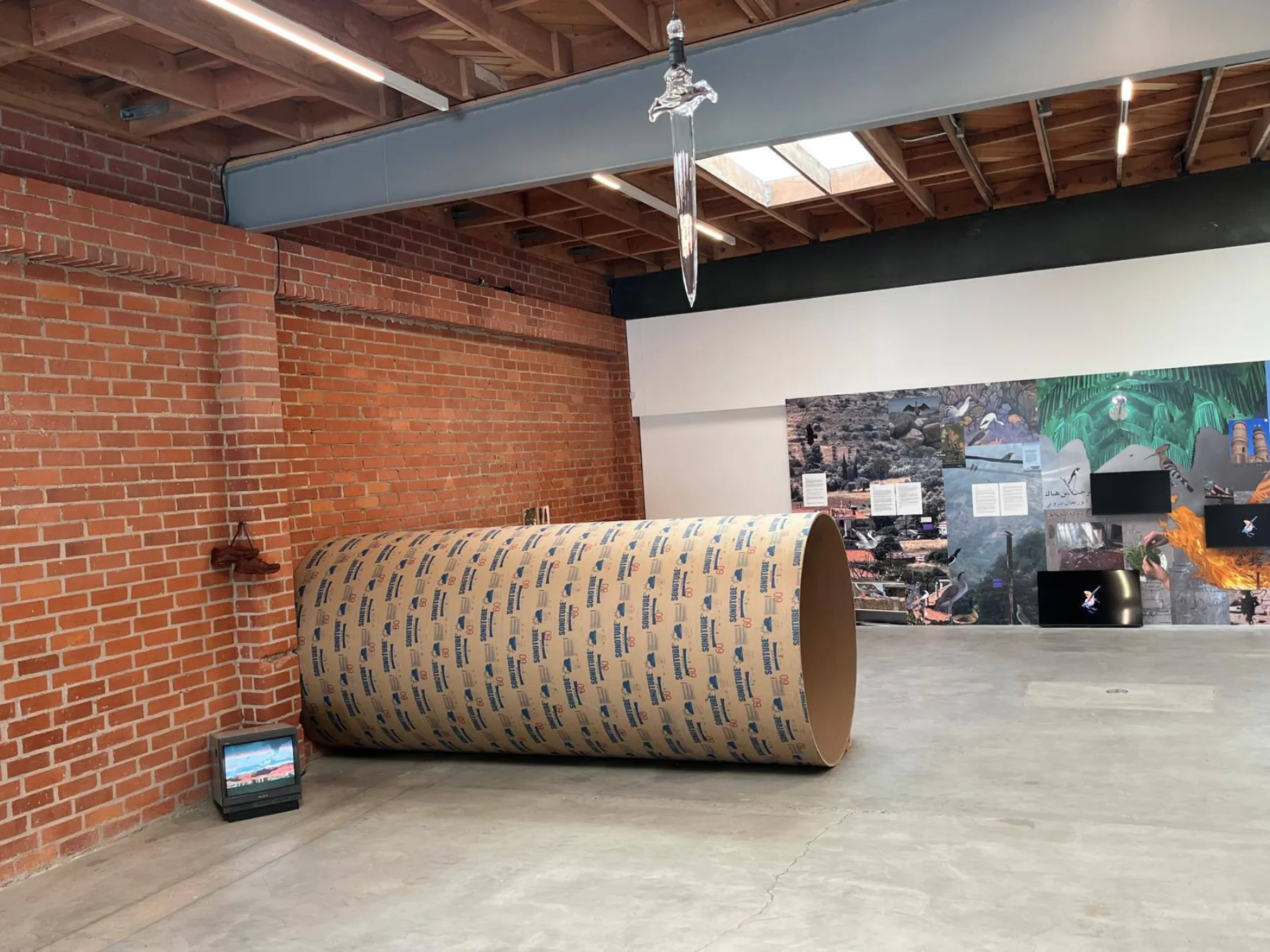 The installation within the group exhibition, with a hanging sculptural element above.